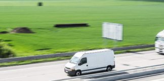 Il corriere e il suo il pacco. Sorprese che non ti aspetti. Corriere su furgone bianco in autostrada