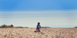 Dove inizia l’educazione digitale dei bambini? Bambino da solo alla scoperta nella sabbia: dove inizia l'educazione digitale dei bambini?